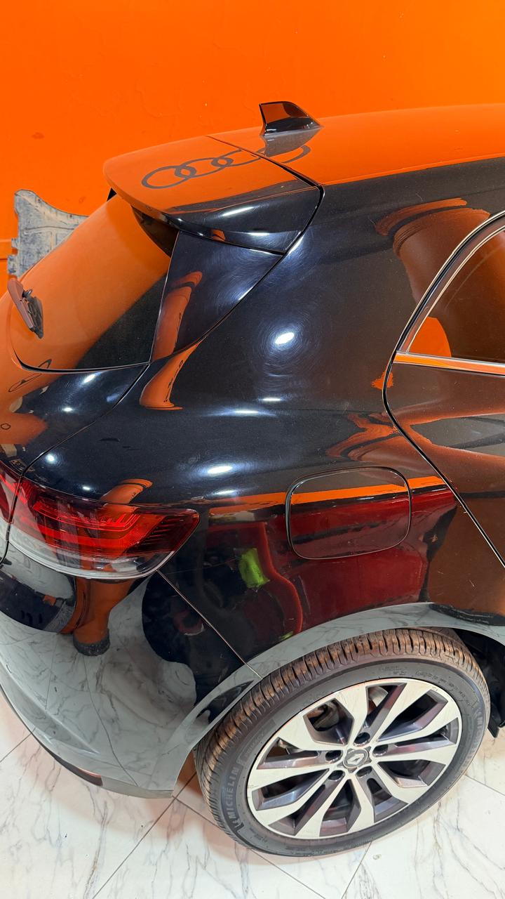 Reflets et marques superficielles visibles sur une carrosserie noire à l’atelier
